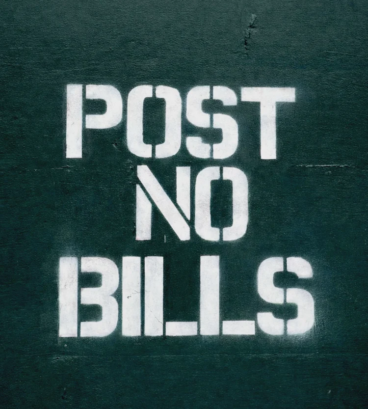 Crisp white stencil on smooth dark-green masonry, with the N set at an angle.